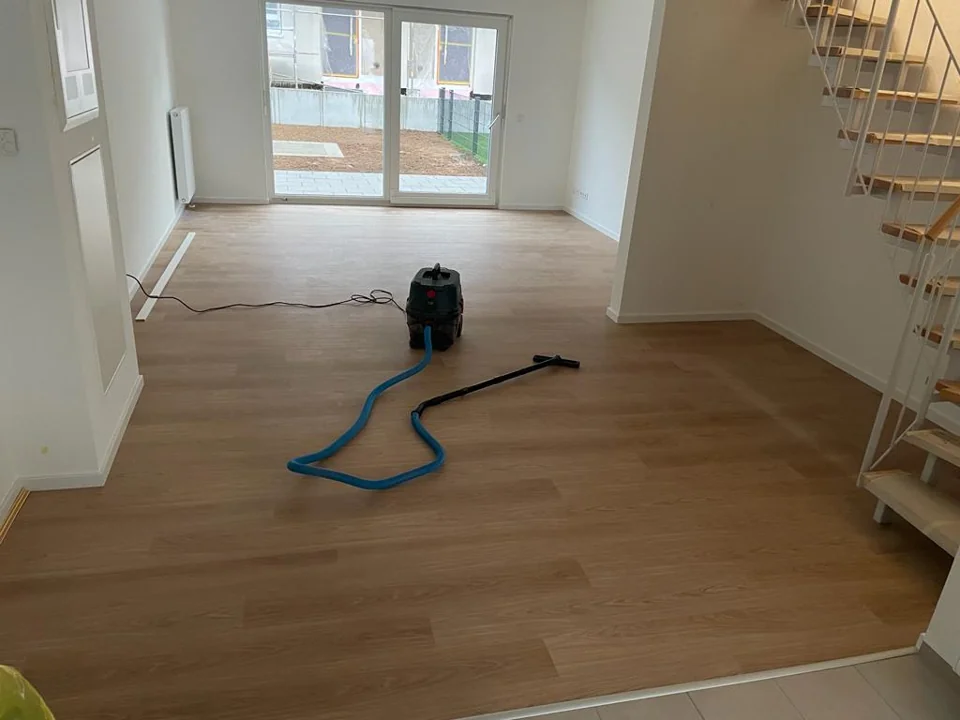 Heller Innenraum mit Boden in Holzoptik und Staubsauger
