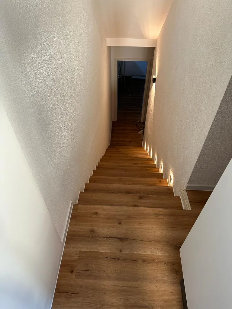 Treppenlauf zwischen hellen Wänden